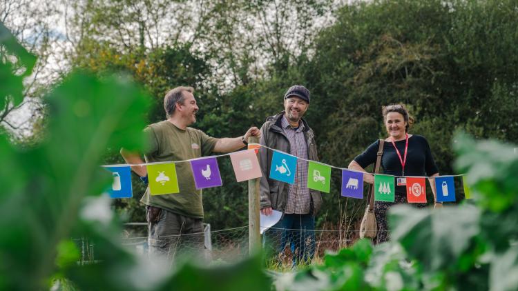three people stood at fence in garden