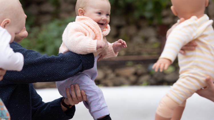 Baby being help up in a baby yoga session