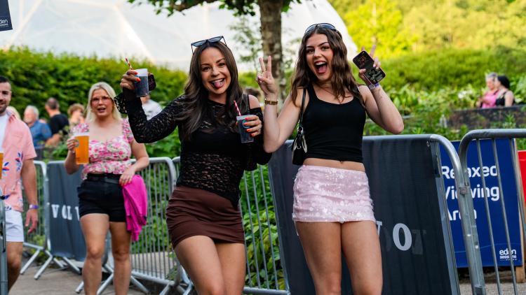 Women walking with drinks smiling and posing for the camera