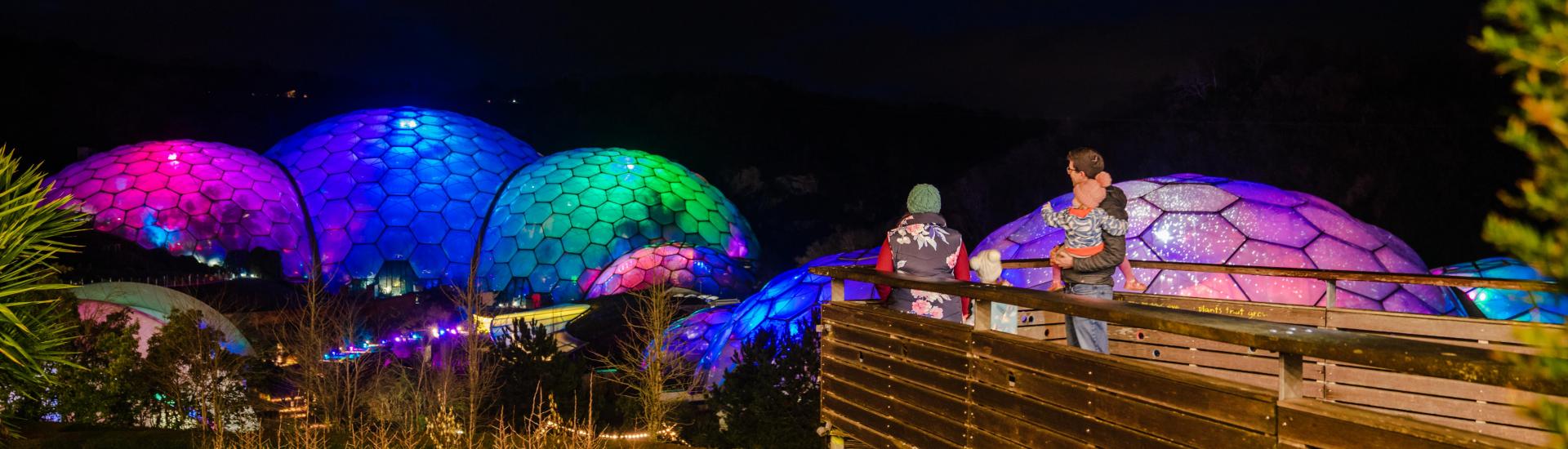 Family admiring lit-up Biomes at Christmas