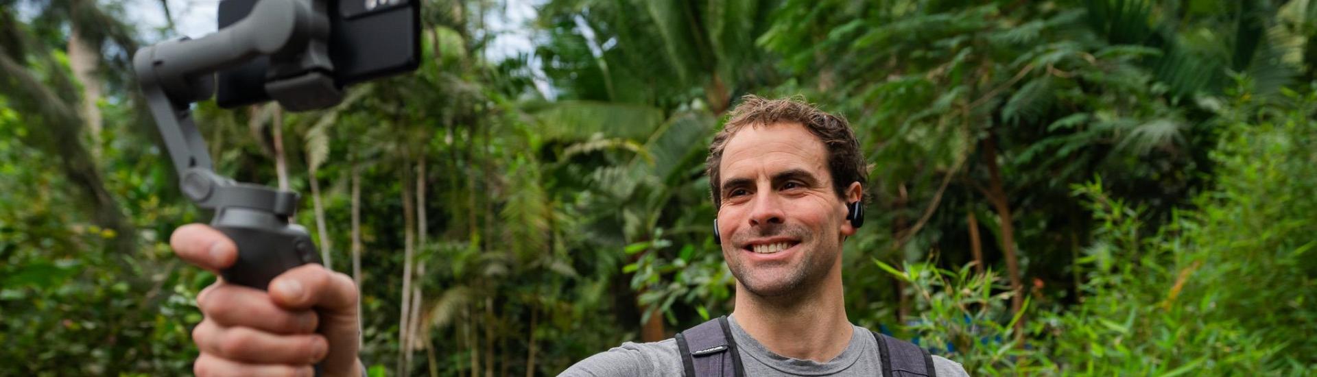 The Eden Project's education team lead, Robbie Kirkman, holds a live streaming camera up in the Rainforest Biome